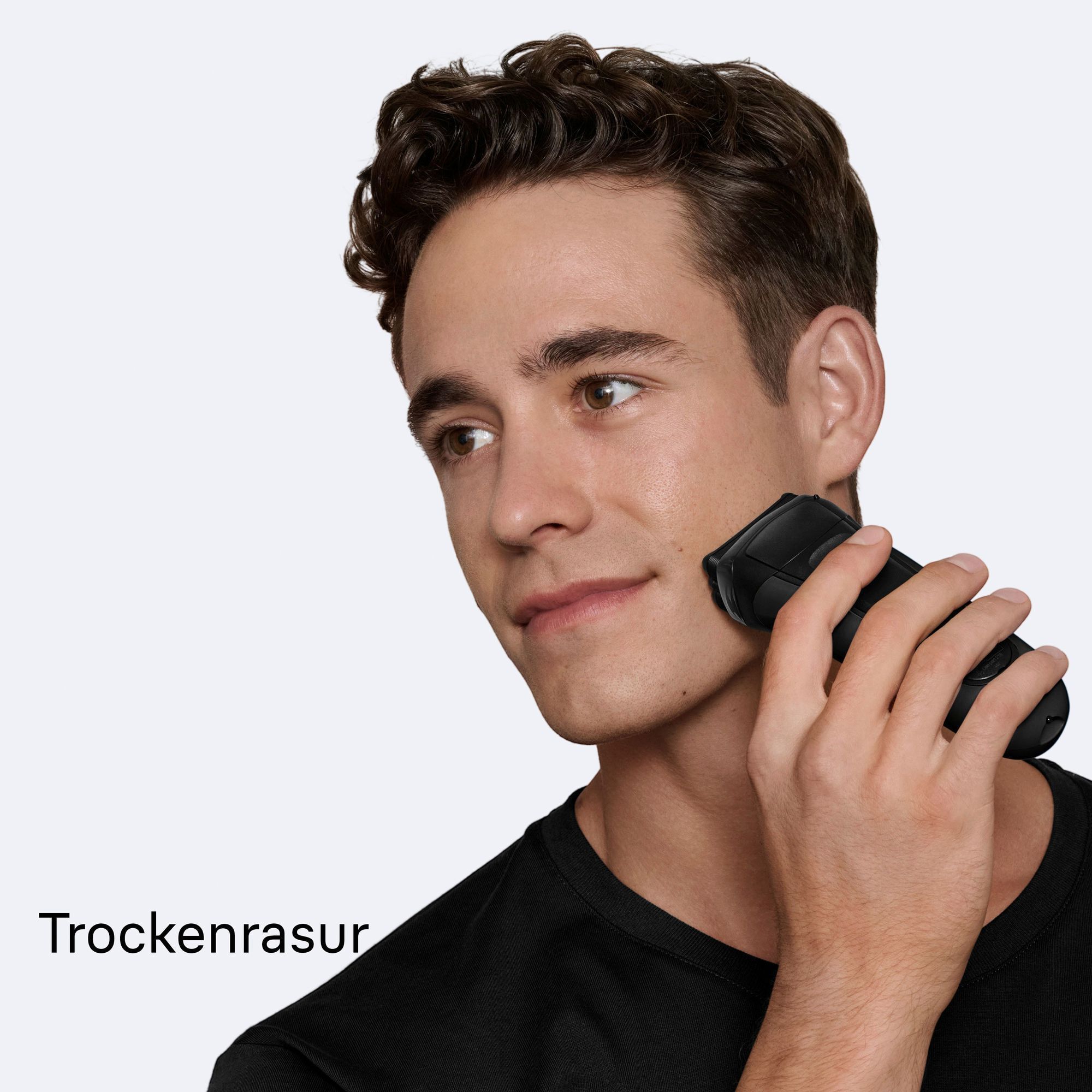 Mann rasiert sich trocken mit einem Braun Rasierer für eine glatte Haut.
