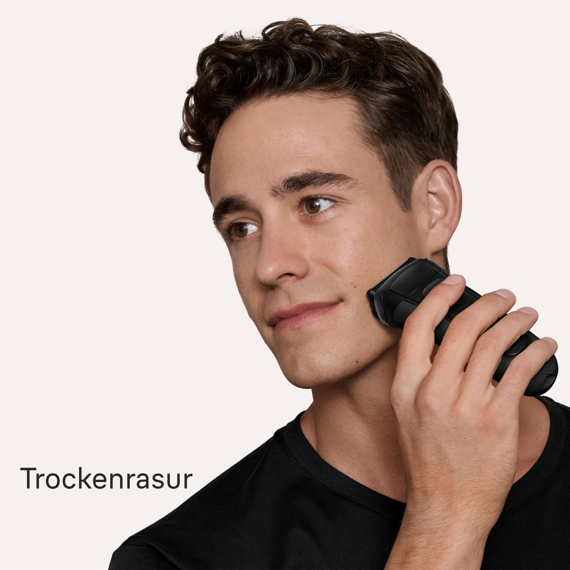 Junger Mann, der den Rasierer verwendet